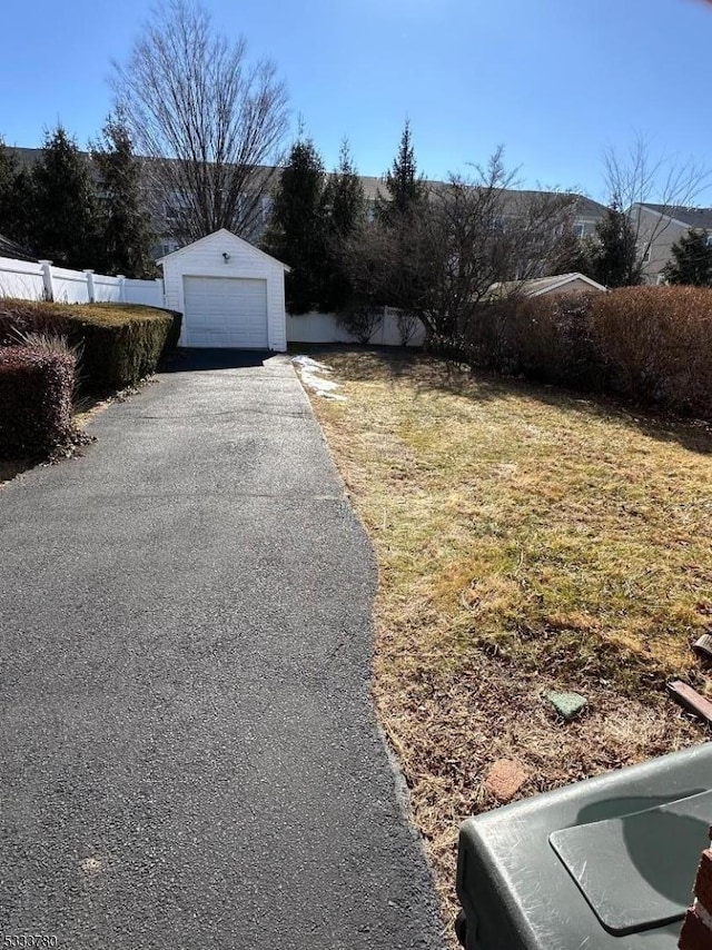 view of yard with a garage and an outbuilding