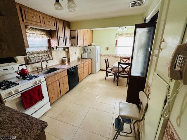 kitchen featuring tasteful backsplash, white appliances, sink, and light tile patterned floors