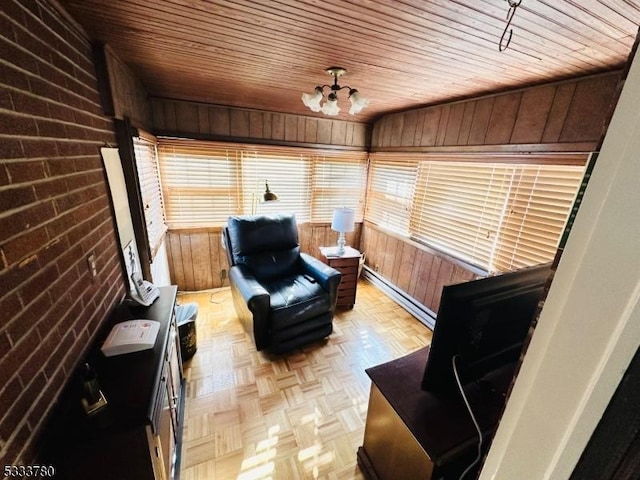 sitting room with light parquet flooring, wood walls, brick wall, and baseboard heating