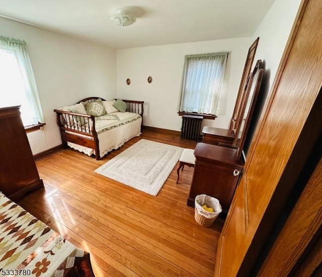 bedroom with radiator and light wood-type flooring