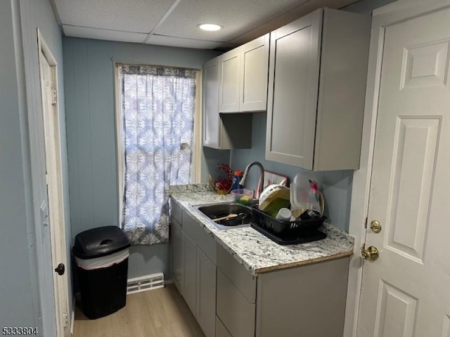 laundry room featuring sink and light hardwood / wood-style flooring