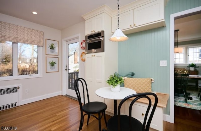 dining space featuring hardwood / wood-style floors and radiator heating unit