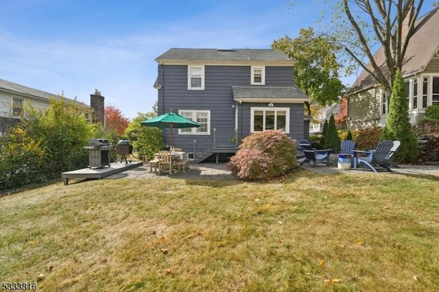 rear view of house featuring a yard and a patio