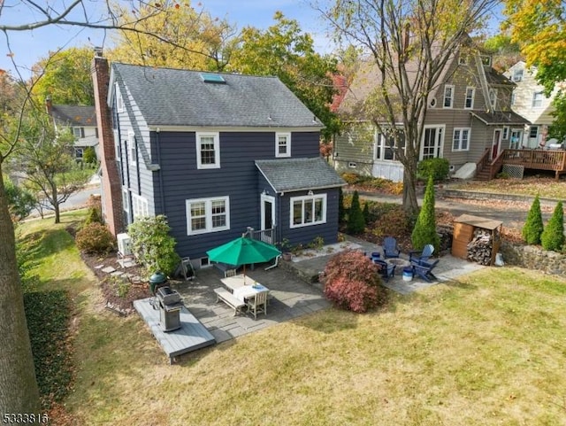 back of house with a patio, a yard, a deck, and an outdoor fire pit