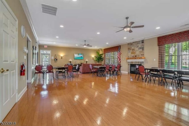 dining room with recessed lighting, light wood-style flooring, visible vents, and a stone fireplace