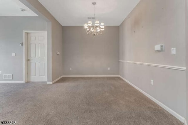 empty room with baseboards, visible vents, a notable chandelier, and carpet flooring