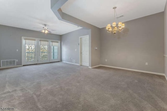 carpeted empty room with ceiling fan with notable chandelier, visible vents, and baseboards