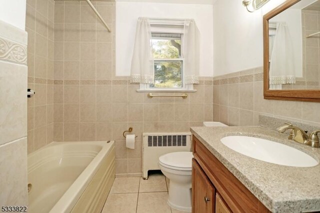 full bathroom with toilet, tile walls, vanity, radiator, and tile patterned flooring