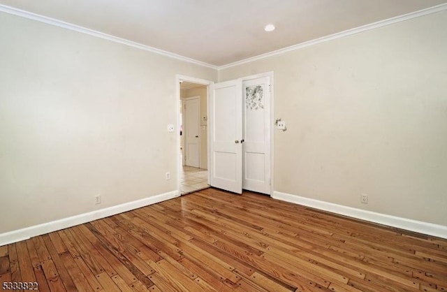 empty room with crown molding and hardwood / wood-style floors