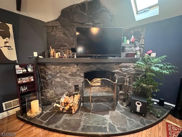 details with a skylight, a fireplace, and hardwood / wood-style floors