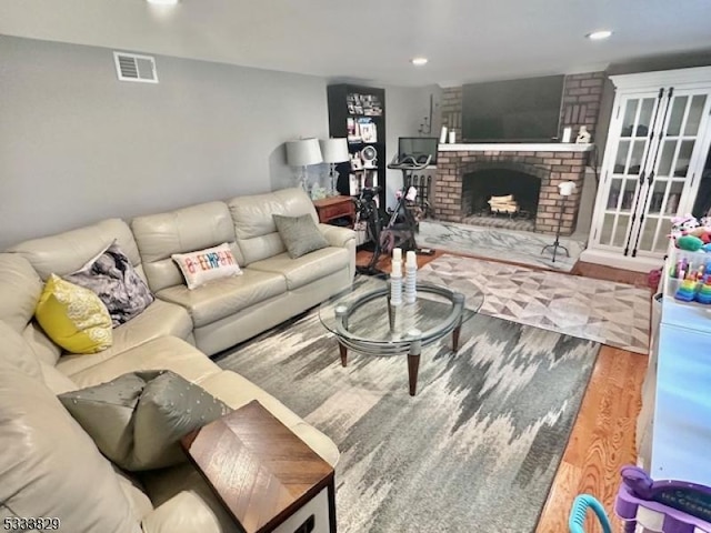 living room featuring wood-type flooring and a fireplace