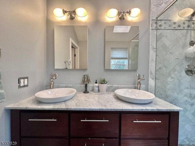 bathroom featuring tiled shower and vanity