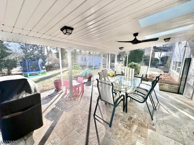 sunroom / solarium with ceiling fan and a skylight