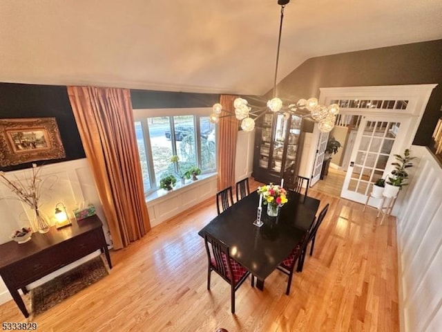 dining room with lofted ceiling and light hardwood / wood-style floors