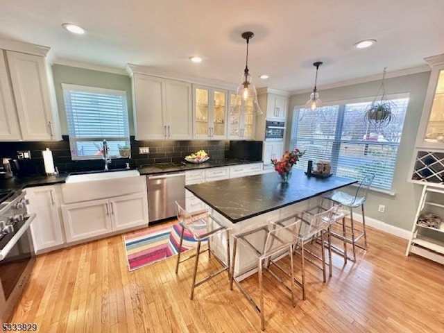 kitchen with stainless steel appliances, pendant lighting, white cabinets, and sink