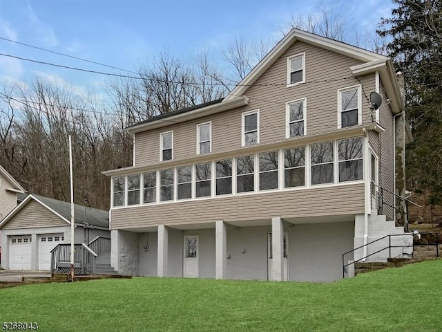 view of front of property featuring a front yard, a garage, and a sunroom