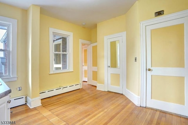 entryway with light wood-type flooring and baseboard heating