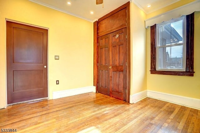 unfurnished bedroom featuring crown molding, a closet, and light wood-type flooring