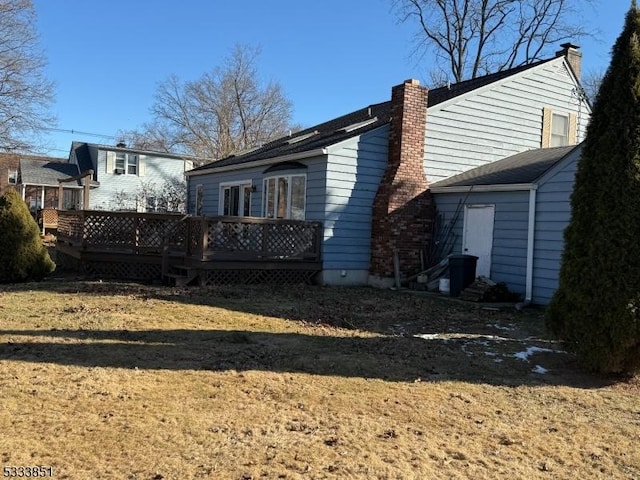 view of side of property with a deck and a lawn