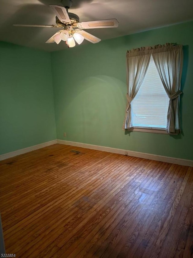 spare room with wood-type flooring and ceiling fan