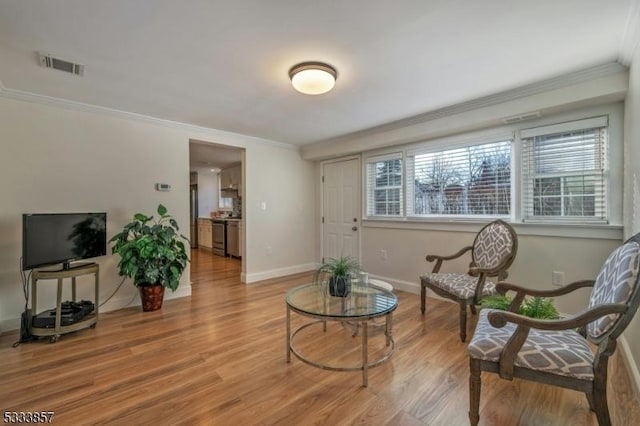 sitting room with ornamental molding and light hardwood / wood-style floors