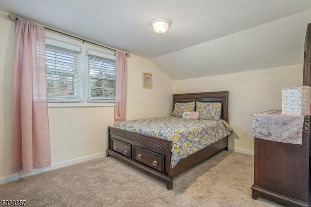 bedroom featuring vaulted ceiling and light carpet