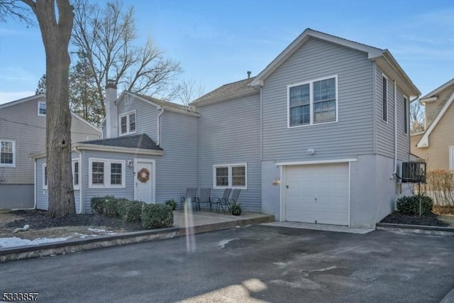 view of front property featuring a garage and central air condition unit