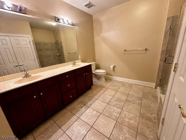 bathroom featuring tile patterned floors, vanity, toilet, and an enclosed shower