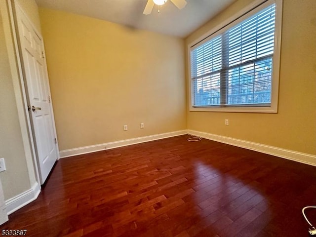 unfurnished room featuring dark wood-type flooring and ceiling fan