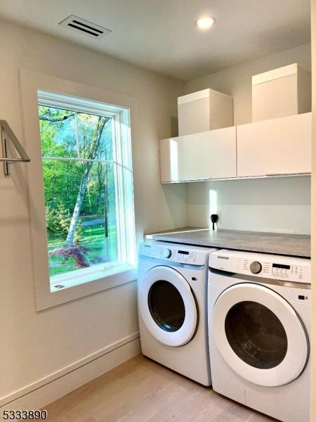 360 Spring Hill Rd, Montgomery Twp, NJ 08558 - laundry area featuring visible vents, baseboards, light wood-style floors, cabinet space, and independent washer and dryer
