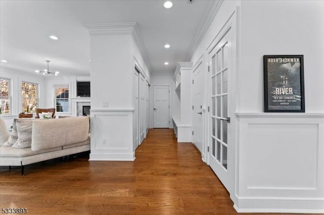 hall featuring an inviting chandelier, dark hardwood / wood-style floors, and ornamental molding