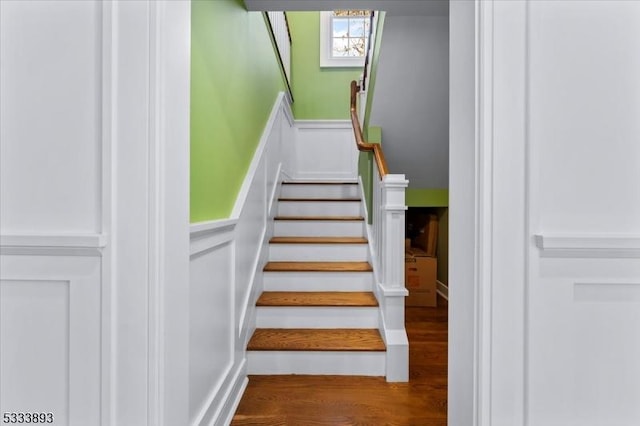 staircase featuring a skylight and wood-type flooring