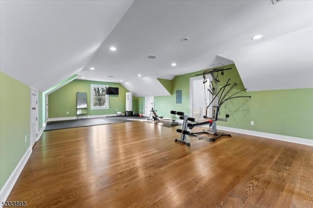 exercise area with hardwood / wood-style flooring and vaulted ceiling