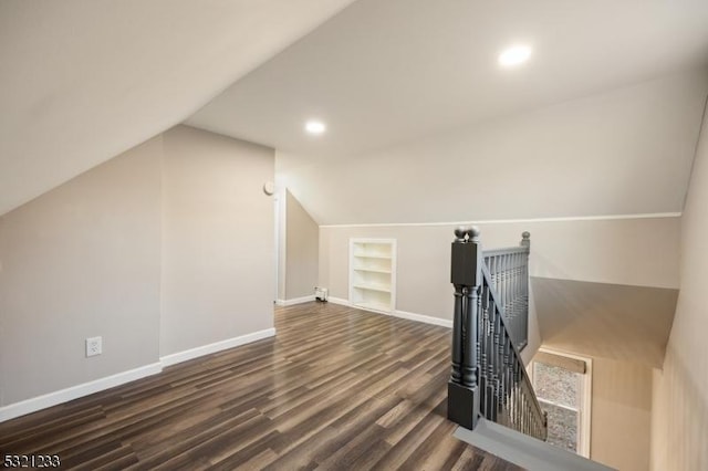 bonus room with lofted ceiling, built in features, and dark hardwood / wood-style floors