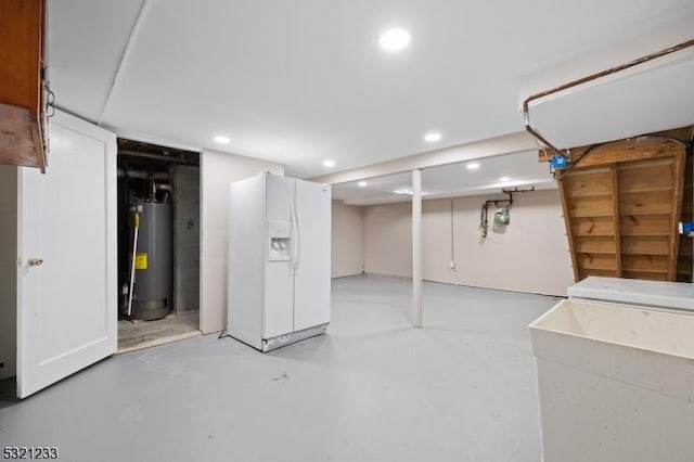 basement with water heater, sink, and white fridge with ice dispenser