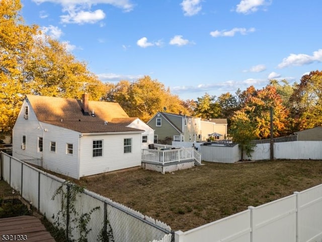 back of house featuring a yard and a deck