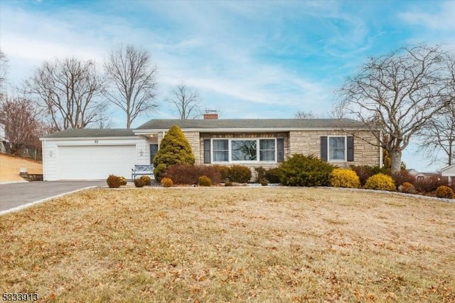 ranch-style home with a garage and a front lawn