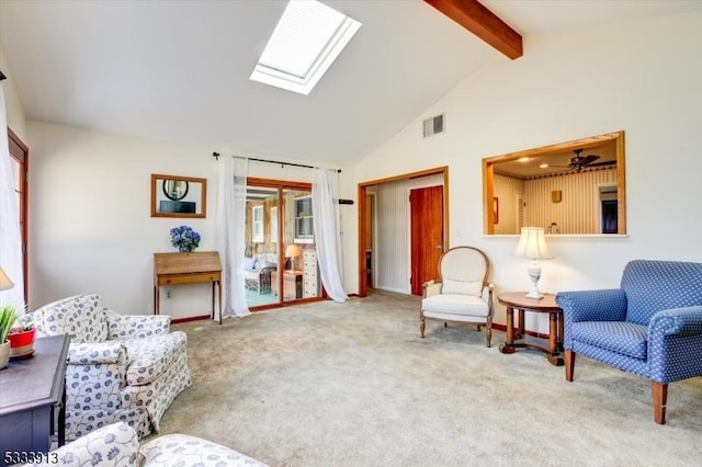 carpeted living room with beam ceiling, high vaulted ceiling, and a skylight