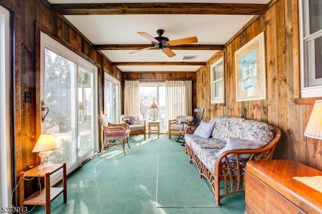 sunroom featuring ceiling fan and beam ceiling