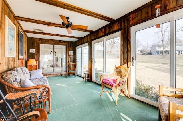 sunroom featuring beam ceiling and ceiling fan