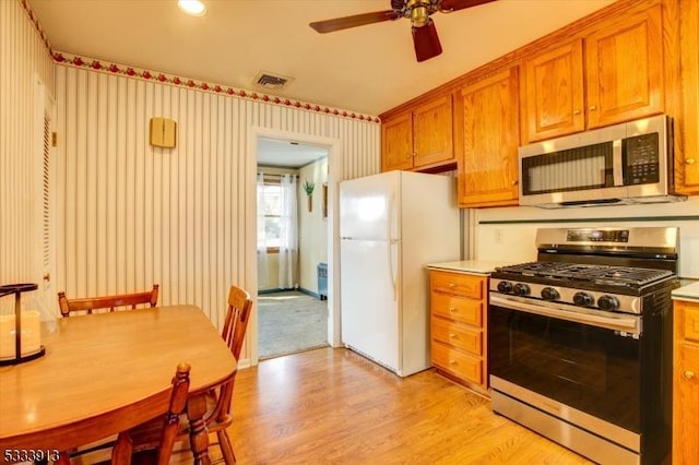 kitchen featuring light hardwood / wood-style floors, ceiling fan, and stainless steel appliances