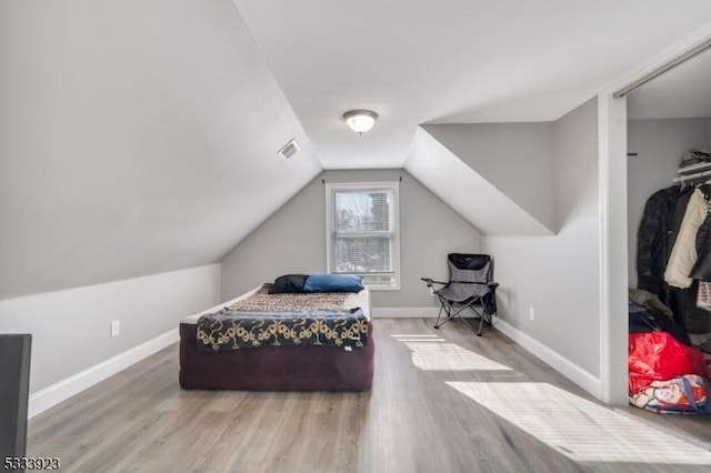 bedroom featuring hardwood / wood-style flooring and vaulted ceiling