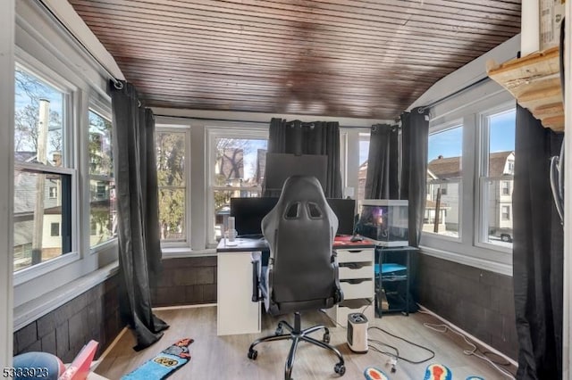 home office featuring lofted ceiling, wooden ceiling, wooden walls, and light hardwood / wood-style flooring