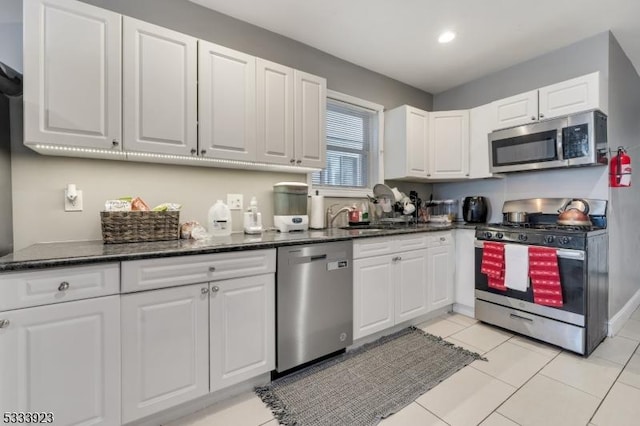 kitchen with stainless steel appliances, sink, and white cabinets