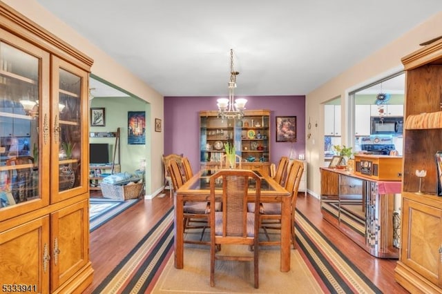 dining space with a notable chandelier and light wood-type flooring