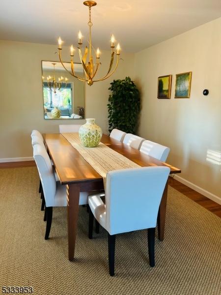 dining area with a notable chandelier, baseboards, and wood finished floors