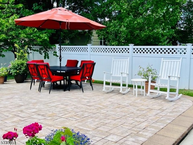 view of patio with outdoor dining space and fence