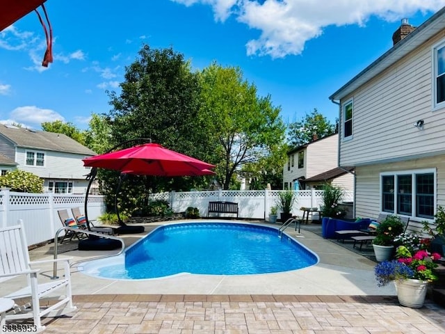 view of swimming pool featuring a fenced in pool, a fenced backyard, and a patio area