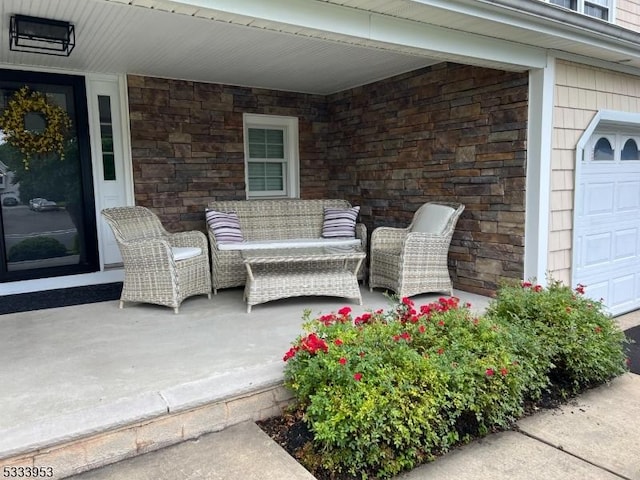 view of patio / terrace with covered porch, outdoor lounge area, and a garage