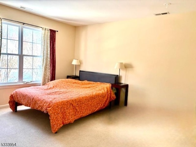 carpeted bedroom featuring visible vents